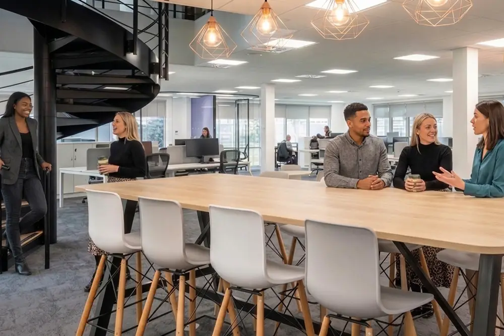 Team members in an office space having conversations.