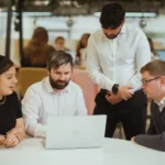 Team meeting around laptop