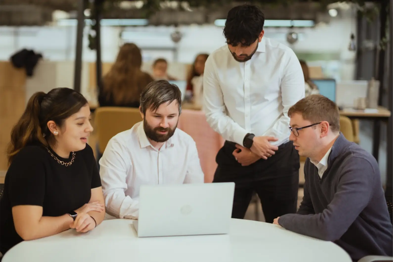 Team meeting around laptop