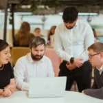 Team meeting around laptop