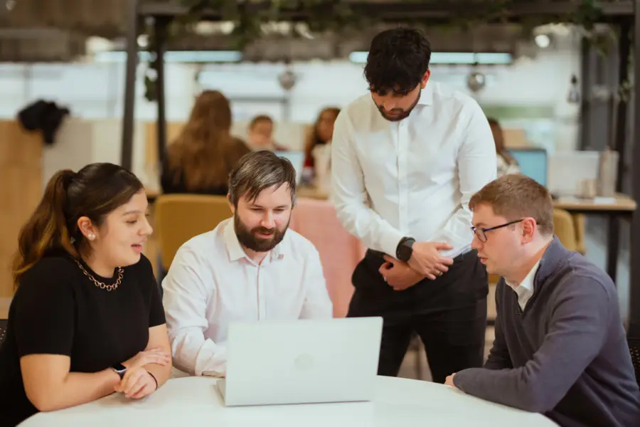 Team meeting around laptop