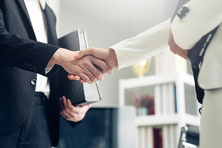 2 people shaking hands during project handover